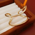 Detailed close-up of a wavy gold double-layered ring in a premium velvet jewelry box - Gold