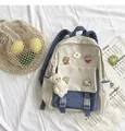 Close-up of canvas backpack details with cute cartoon pins and plush bear charm - Blue + 5a Badge + Blush Bear