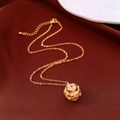 Macro shot of gold necklace with hollow flower pendant and pink gem on red fabric - Hollow Sphere Necklace (WN2291) / Gold