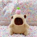 Plush Capybara keychain with pink peach accessory and silver bead chain on colorful background - Light Brown Peach + Bead Chain