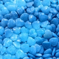 Pile of blue quartz heart stones showing natural texture and polished surface finish - Synthetic Blue Jade