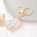 Detail of heart keychain with sparkling clear and iridescent rhinestones on gold metal - White