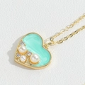 Macro shot of heart-shaped mint green pendant necklace with pearls and rhinestones - Lake Blue Enamel Heart