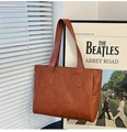 Minimalist brown PU leather tote bag in a stylish interior setting with soft lighting - Yellow Brown