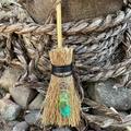 Close-up of Wicca mini broom with silver pentagram and green crystal stone pendant - Pentagram with Green Crystal