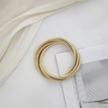 Detailaufnahme des vergoldeten Schlangenarmbands mit mehrlagigen metallischen Windungen - Gold