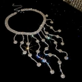 Macro detail of the sparkling multi-layer diamond fringe necklace on a sleek black background - Round Tassel Style / Silver