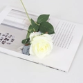 Single white velvet artificial rose with green leaves on an open magazine - Silk Milky White