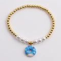 Bracelet élégant en perles de cuivre doré, perles blanches et pendentif donut bleu - Bleu
