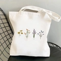 Weiße Canvas-Tragetasche mit Vintage-Cosmos-Blumendrucken auf einem Metallgitterstuhl - Vierfarbiges Blumenset