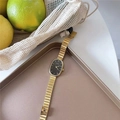 Detail of oval quartz watch and gold bracelet set on a vintage bronze tray - Single-Gold Case Black Dial