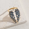 Luxury 14K gold-plated open ring featuring blue zircon wings on a white stone background - Gold Blue Zirconia