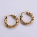 Close-up of golden twisted rope hoop earrings with polished metallic texture and shine - Gold