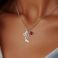 Silver necklace with red birthstone and hollow floral pendant worn by model - January