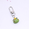 Detailed view of a cute resin green frog prince keychain with yellow crown and silver clasp - Crown Frog