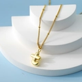 Golden bubble letter T pendant necklace with fine chain on minimalist display - Letter T(T)