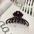 Detail of a burgundy claw clip with heart cutouts on a magazine page background - Approx 11cm / Coffee