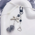 Schattige pluche hondentas hanger met zwarte strik en hartkralen op een wit hartplateau - Grijze Hond