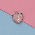 Macro shot of 13mm heart-shaped pink resin pendant with silver metal bezel and glitter - Pink Style(24)