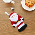Santa Claus cutlery holder for Christmas table setting on a wooden background - Santa Claus