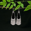 Detailed view of ethnic silver tassel earrings with geometric hollow patterns on a branch - Long Drop Tassel Silver Style (E3779)