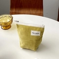 Vintage gelbe Cord-Kosmetiktasche mit weißem Reißverschluss auf weißem Tisch - Zitronengelb