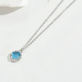 Macro shot of silver chain with a round blue enamel dolphin pendant and zircon borders - Marine Theme (Lake Blue)