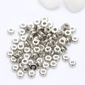 Silver metal donut spacer beads for DIY jewelry making displayed on white fabric - 3mm / Platinum/Color Retention