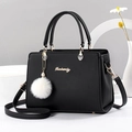 Classic black women's handbag with white fur ball and gold hardware on minimalist background - Black
