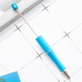 Blue metallic DIY beadable pen with retractable rod and silver cone tip on desk - Sky Blue
