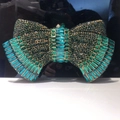 Detailed close-up of bow-shaped clutch bag with gradient green crystal rhinestones - Dark Green Gold Hardware