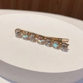 Macro detail of gold bobby pin with seven sparkling crystal rhinestones and AB stones - Round Rainbow