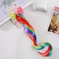 Close-up of a rainbow unicorn bow hairclip with long curly synthetic wig attachment - Colorful