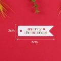 Dettaglio macro etichetta regalo bianca Merry Christmas 2cm x 7cm su sfondo rosso - LH-338 (Confezione da 100 Pezzi)