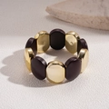 Detalle de pulsera elástica ancha con cuentas ovaladas en oro pulido y café acrílico - Pulsera-Marrón