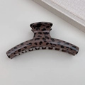 Dettaglio dell'elegante pinza per capelli con stampa leopardata su sfondo neutro - Stile Appendiabiti Leopardo Scuro