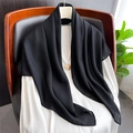 Dettaglio di una sciarpa vintage in cotone e lino nero su sedia con spilla dorata - 90x90cm / Nero
