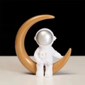 Astronautenbeeldje zittend op een gouden maan met zilveren vizier als decoratie - Zilveren Maan