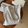 Detalle de bolso tote de lona floral con etiqueta tejida sobre fondo de mesa de madera - Rayas Púrpura Café Flores Caladas