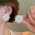 Détail de boucles d'oreilles fleurs en perles blanches faites main portées par un modèle - Style Marguerite Tissée (63#) / Blanc