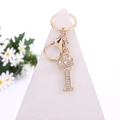 Golden metal keychain featuring crystal rhinestone letter P with a crown on white stand - Letter I / Gold