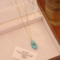 Gros plan du collier doré avec pendentif marquise turquoise et gemme rouge sur bois - 6# Turquoise