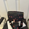 Chic black fanny pack featuring vibrant red cherry patterns and gold zipper accents - Black