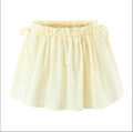 Detail of pale yellow mini skirt featuring ruffled waist and adjustable side drawstrings - Yellow Skirt