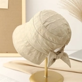 Women's quilted plaid bucket hat with rear bow detail on elegant gold display stand - M / Beige