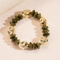 Dettaglio di perline in resina verde oliva e segmenti dorati su un bracciale stile vintage - Bracciale-Verde Oliva