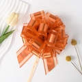 Top view of bright orange organza pull bow ribbon for elegant gift box packaging - Orange