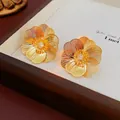 Elegant gold plated hollow flower stud earrings with shimmering zircon center stone - Gold (Silver Earring Post)
