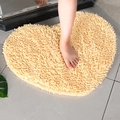 Beige heart shaped chenille bath mat with absorbent soft plush texture on bathroom tile - Beige