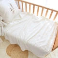 Morbida coperta bianca per neonati con texture 3D a pois in una culla accogliente - Coperta Minky Bianca